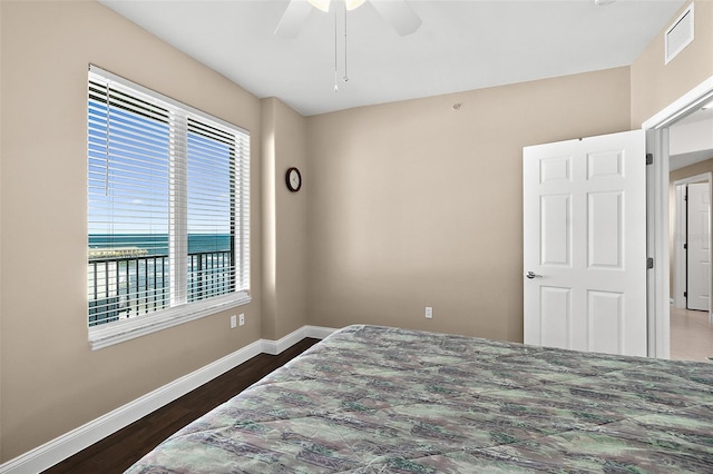 bedroom with ceiling fan, dark hardwood / wood-style flooring, and multiple windows