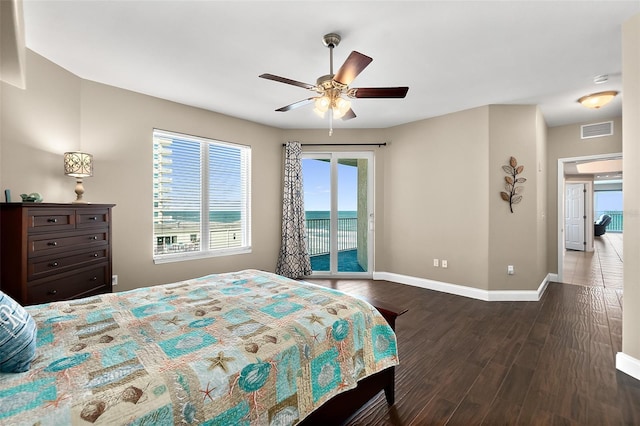 bedroom with ceiling fan, access to exterior, dark hardwood / wood-style flooring, and a water view