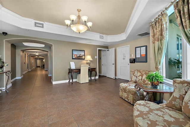 living room featuring crown molding, a raised ceiling, and a chandelier