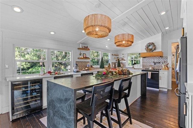 kitchen featuring wine cooler, lofted ceiling, wood ceiling, white cabinetry, and a kitchen island