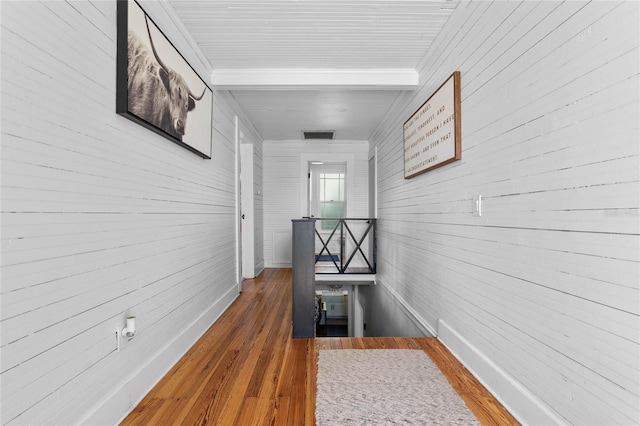 hallway with dark wood-type flooring and beamed ceiling