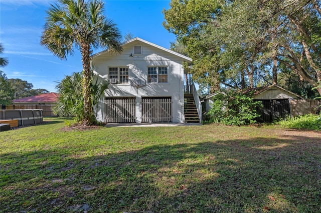 rear view of house featuring a yard and a swimming pool