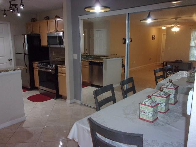 tiled dining space featuring ceiling fan