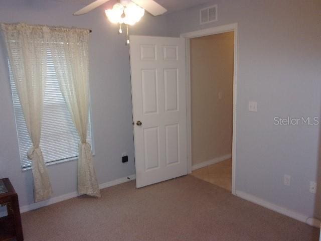 unfurnished bedroom with ceiling fan and carpet floors