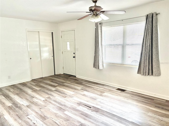 foyer entrance with ceiling fan and light hardwood / wood-style flooring