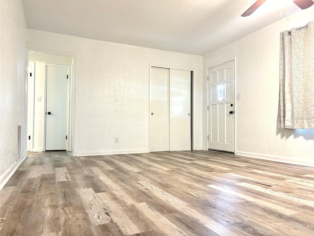 empty room with light wood-type flooring and ceiling fan