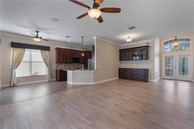 unfurnished living room with ceiling fan, light wood-type flooring, french doors, a textured ceiling, and ornamental molding