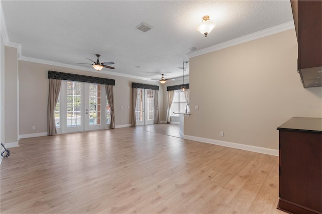 unfurnished living room featuring ceiling fan, a wealth of natural light, crown molding, and light hardwood / wood-style flooring