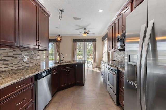 kitchen with stainless steel appliances, pendant lighting, backsplash, and sink