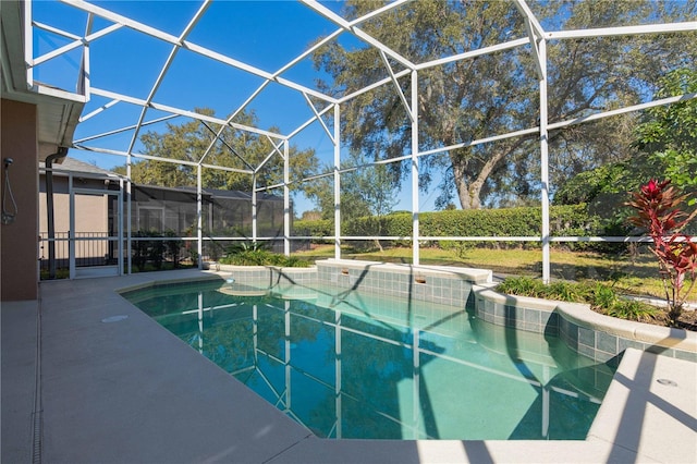 view of pool with a patio area and glass enclosure