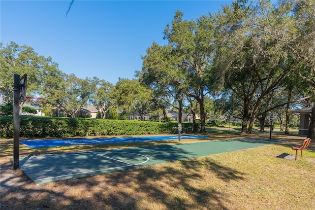 view of sport court with a yard