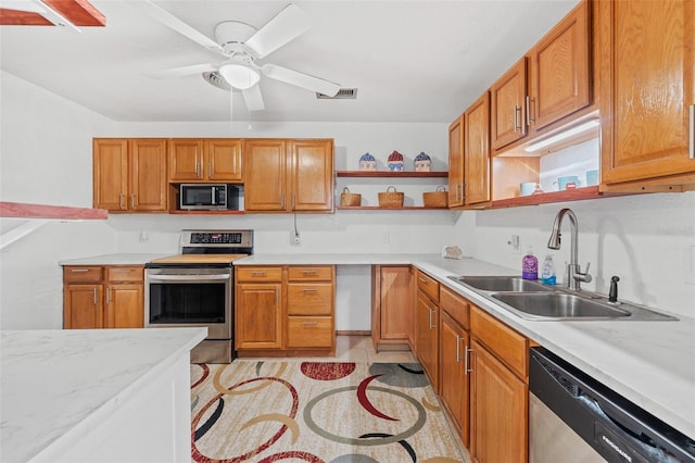 kitchen featuring ceiling fan, sink, appliances with stainless steel finishes, and light tile patterned flooring