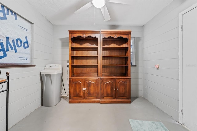 bathroom featuring a textured ceiling, ceiling fan, concrete floors, and wooden walls