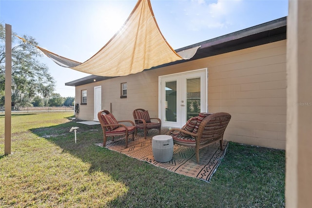 back of property featuring a yard, french doors, and a patio