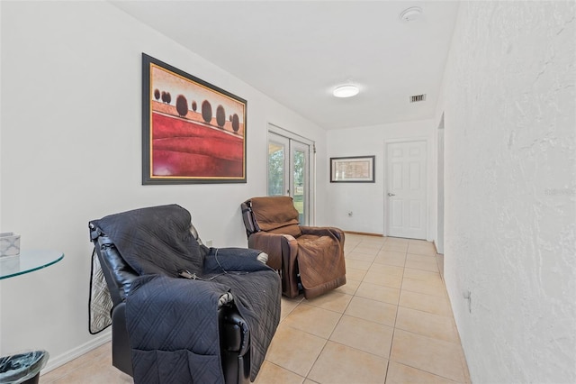 sitting room with light tile patterned floors and french doors