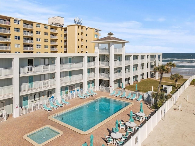 view of swimming pool featuring a water view and a patio