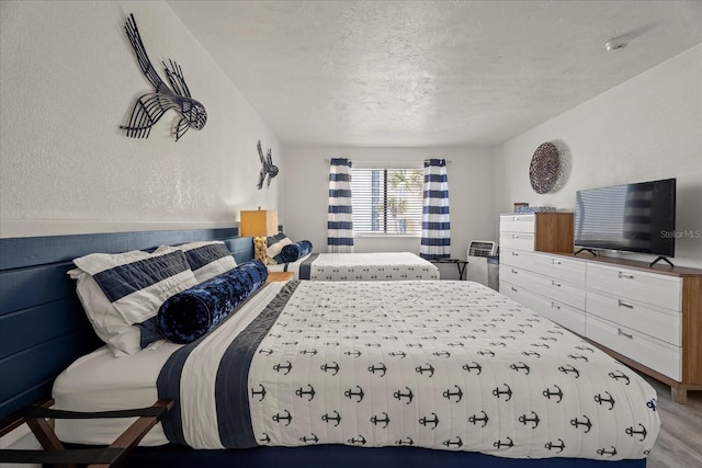 bedroom with light wood-type flooring and a textured ceiling