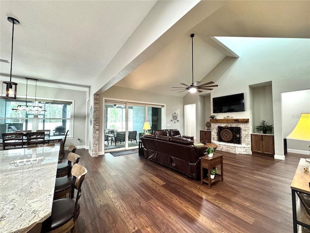 living room featuring ceiling fan, dark hardwood / wood-style flooring, high vaulted ceiling, and a fireplace