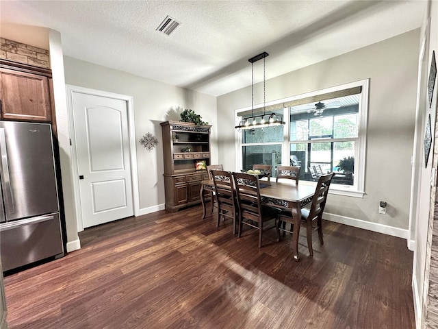 dining room featuring a textured ceiling, a chandelier, and dark wood-type flooring