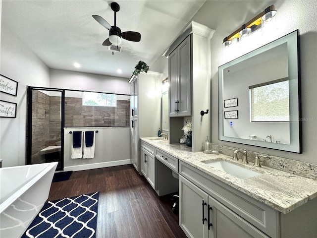 bathroom featuring shower with separate bathtub, ceiling fan, wood-type flooring, and vanity