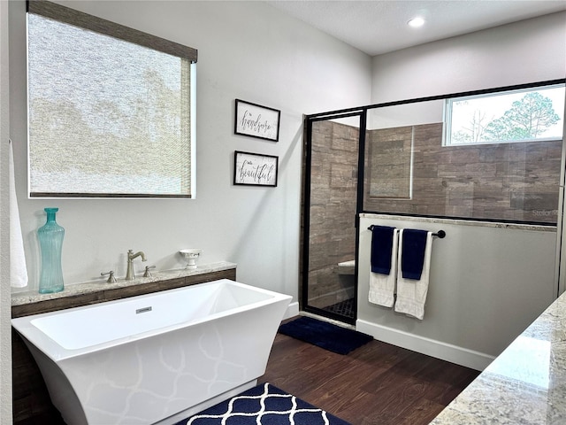 bathroom with independent shower and bath and hardwood / wood-style flooring