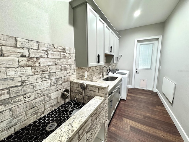 kitchen with separate washer and dryer, dark wood-type flooring, sink, white cabinetry, and tasteful backsplash