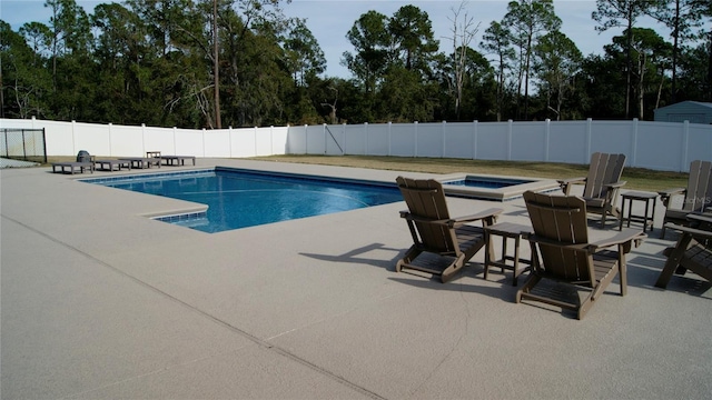 view of swimming pool with a hot tub and a patio area