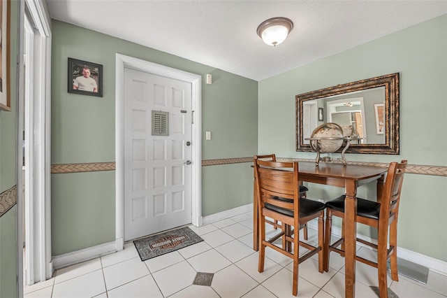 tiled dining space with a textured ceiling