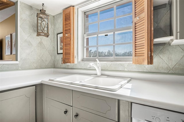 kitchen with white cabinetry, dishwasher, and sink