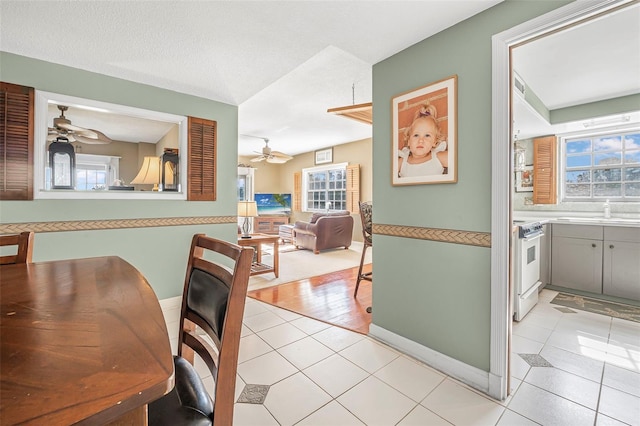 tiled dining room featuring ceiling fan and a textured ceiling