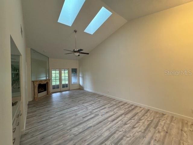 unfurnished living room featuring high vaulted ceiling, ceiling fan, and light hardwood / wood-style flooring