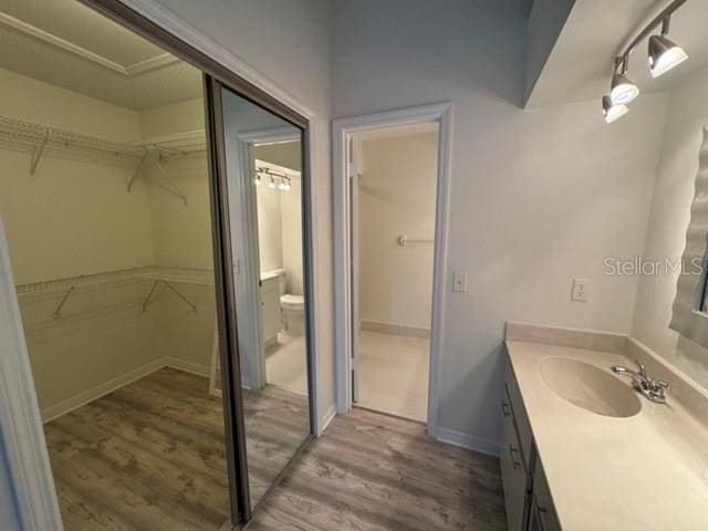 bathroom with toilet, vanity, and hardwood / wood-style floors