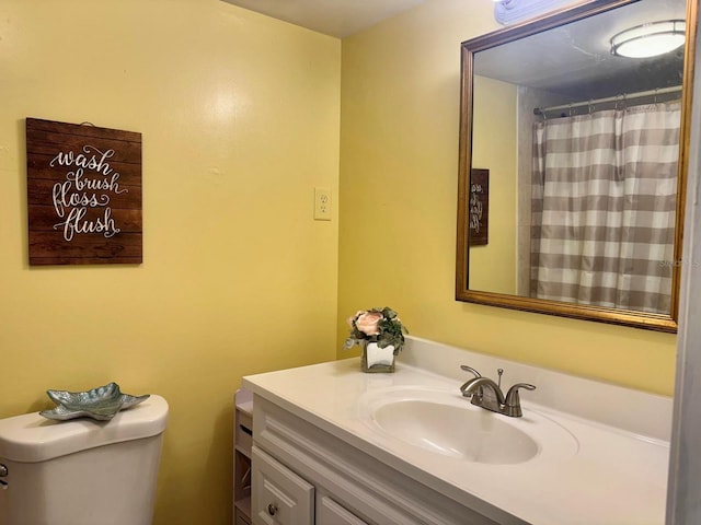 bathroom with toilet, vanity, and curtained shower