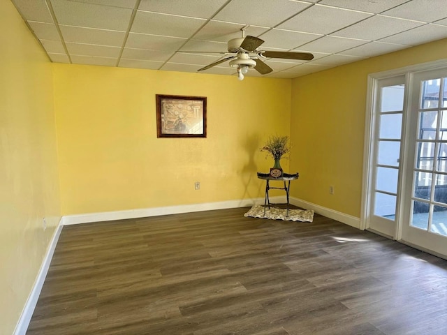 unfurnished room featuring ceiling fan, a paneled ceiling, and dark wood-type flooring