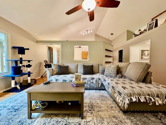 living room with rail lighting, hardwood / wood-style floors, ceiling fan, and lofted ceiling