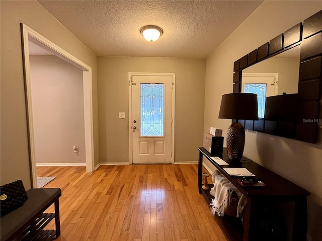 foyer entrance featuring light hardwood / wood-style floors and a textured ceiling