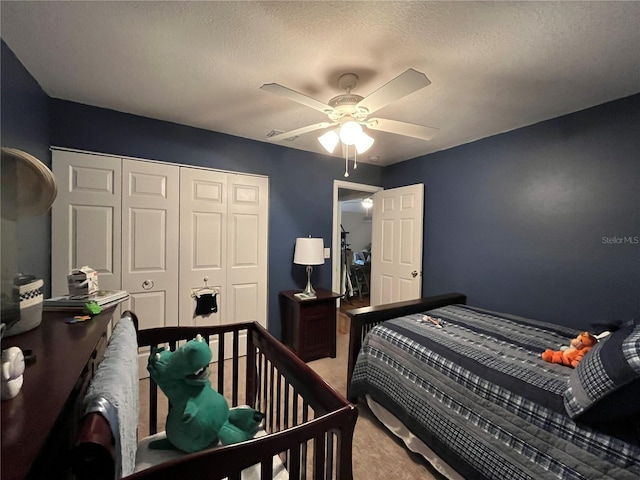 bedroom with ceiling fan, a textured ceiling, a closet, and carpet flooring