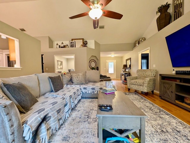 living room with wood-type flooring, vaulted ceiling, and ceiling fan