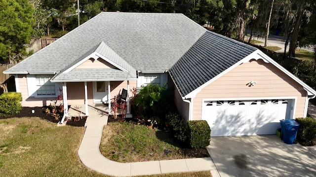 view of front of home with covered porch, roof with shingles, and a front yard