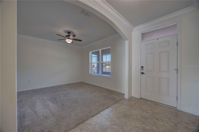 carpeted entrance foyer with ceiling fan and ornamental molding