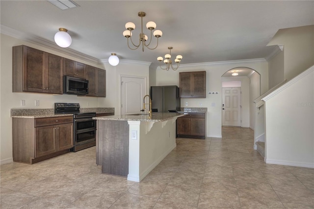 kitchen featuring an inviting chandelier, an island with sink, appliances with stainless steel finishes, pendant lighting, and sink