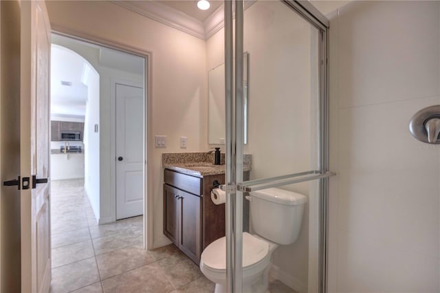 bathroom with toilet, vanity, crown molding, and tile patterned flooring