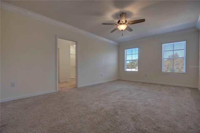 carpeted spare room featuring ceiling fan and ornamental molding