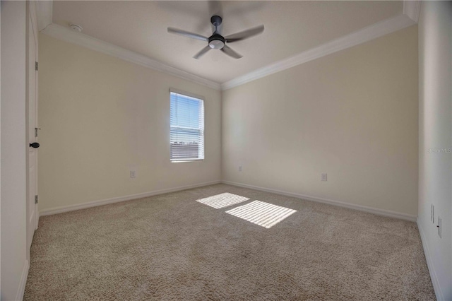 empty room featuring ceiling fan, crown molding, and light colored carpet