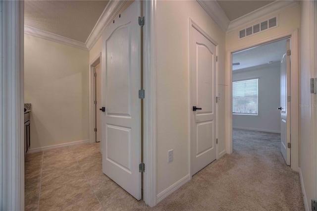 hall with light colored carpet and crown molding