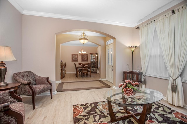 living area with light hardwood / wood-style floors, crown molding, and a notable chandelier