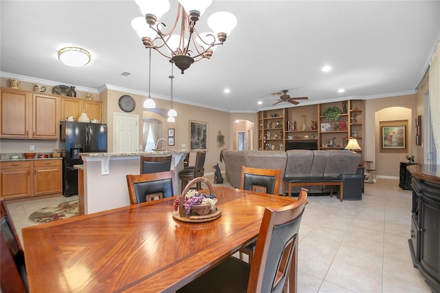 tiled dining room with ceiling fan with notable chandelier and ornamental molding