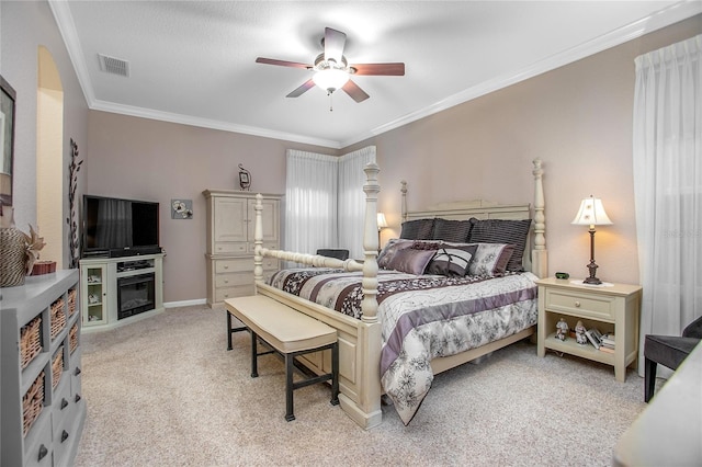 carpeted bedroom with ceiling fan and ornamental molding