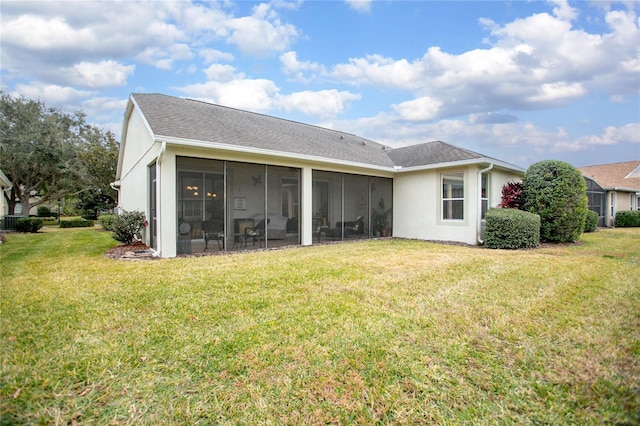 rear view of property featuring a lawn and a sunroom