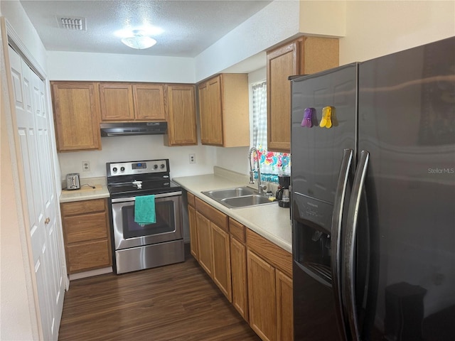 kitchen featuring sink, dark hardwood / wood-style floors, a textured ceiling, and appliances with stainless steel finishes